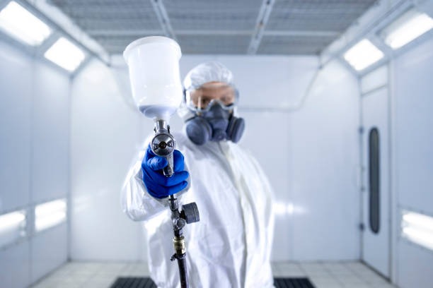 imageye___-_imgi_1_portrait-of-automobile-painter-standing-in-paint-chamber-workshop-holding-painting-gun
